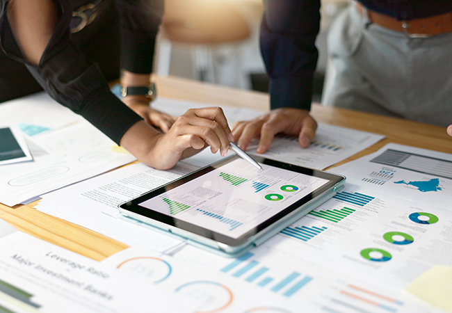 person touching tablet with display of charts