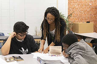 Student teacher in classroom helping students with reading