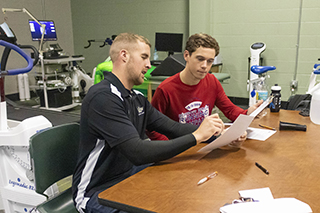 Student and instructor in exercise science lab reviewing reports
