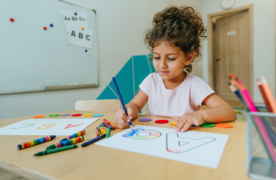 child trying to write the letter a