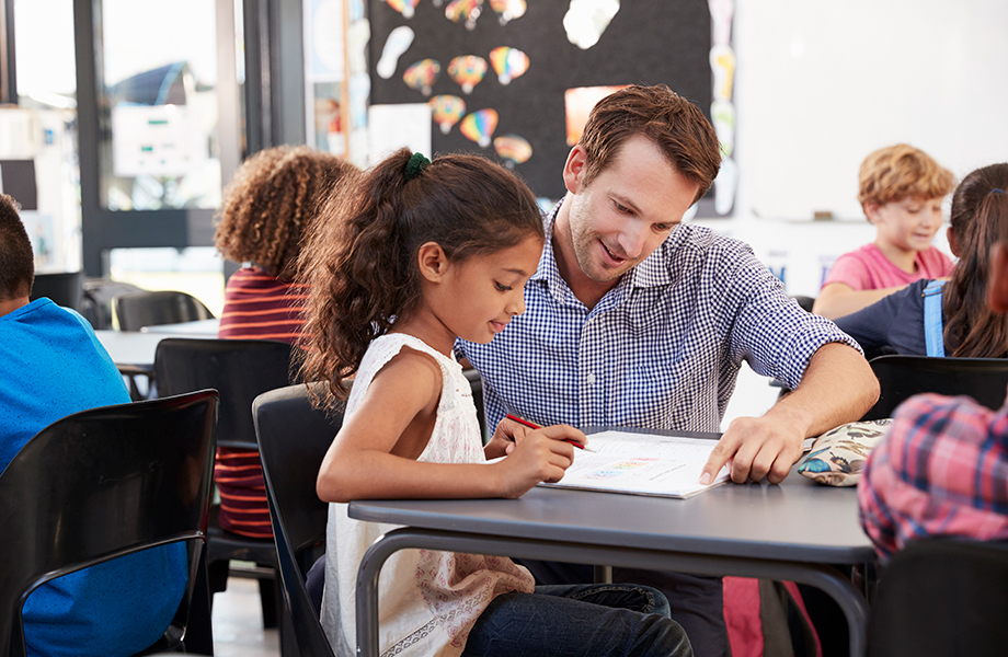 Teacher helping student at their desk