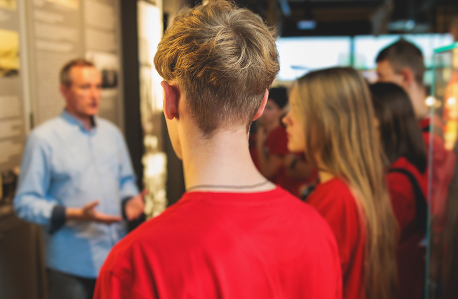 Educator with students at a museum 