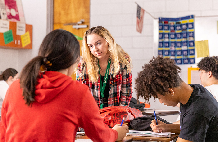 Teacher talking to student at their desk