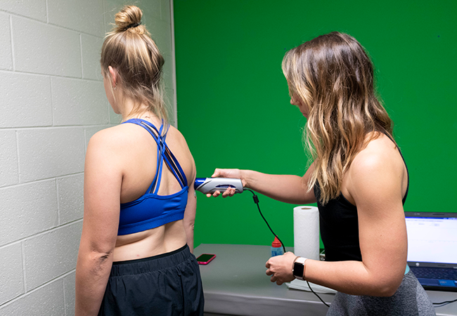 person tests woman's body composition with equipment