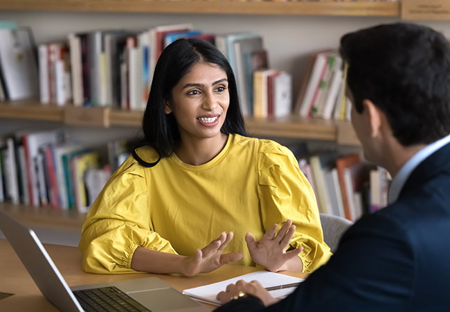 woman talking to man in library setting