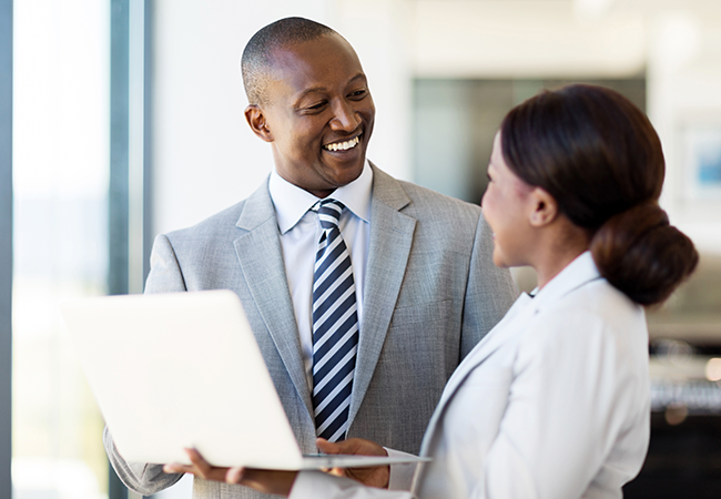 a man in suit stands smiling at woman
