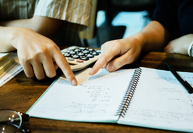 close up of hands of 2 people working on math 