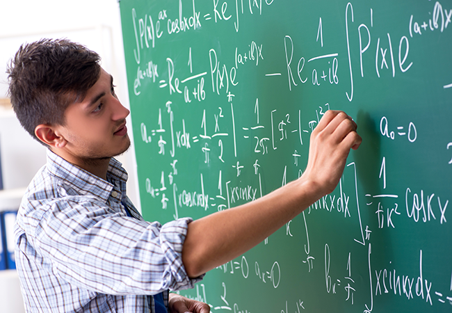 a student writes math equations on the board