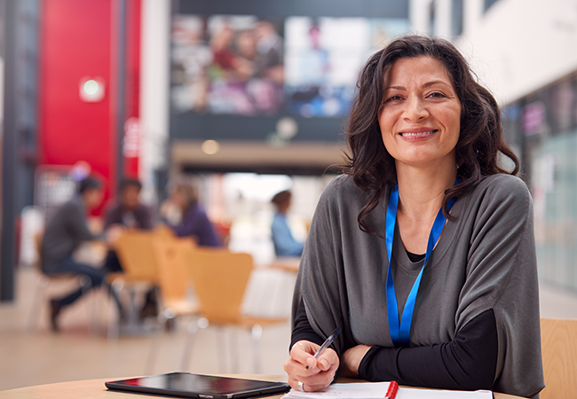a woman smiles directly at camera while in a college student union