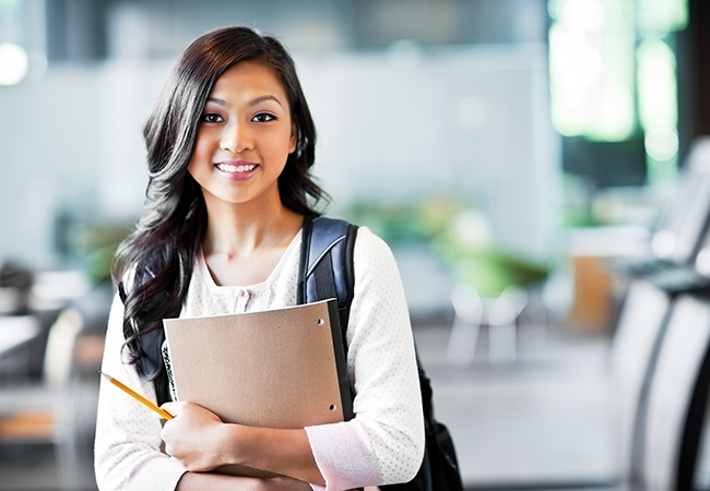 a student with her backpack on smiles at camera