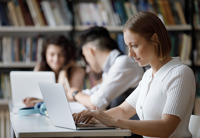 a woman works on her laptop in a library