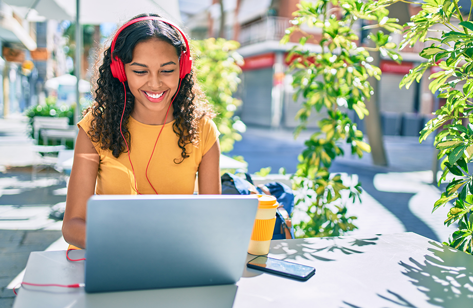 college student at laptop with headhpones on