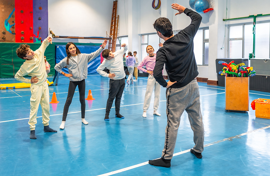 PE teacher stretching with students