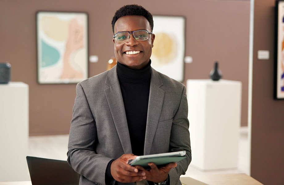 a museum currator stands in a museum smiling at camera