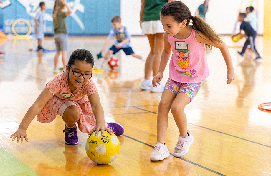 two you elementary aged girls play during pe
