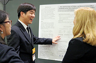 Graduate student giving poster presentation at a research conference