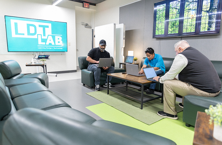 people sit in LTD Lab working on laptops