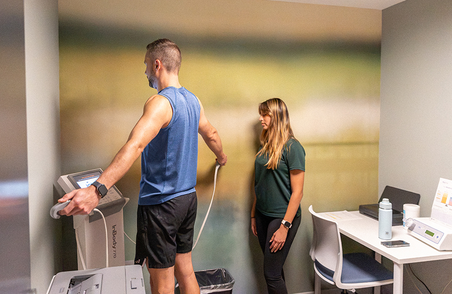 woman assists man in taking measurements on equipment