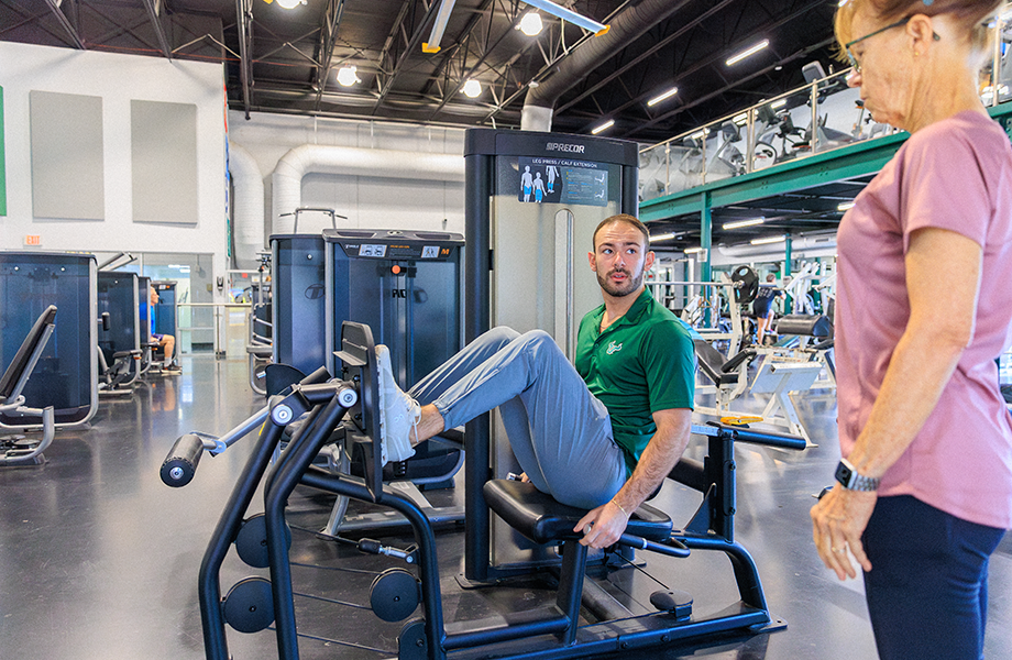 USF staff member demonstrates exercise equipment for client