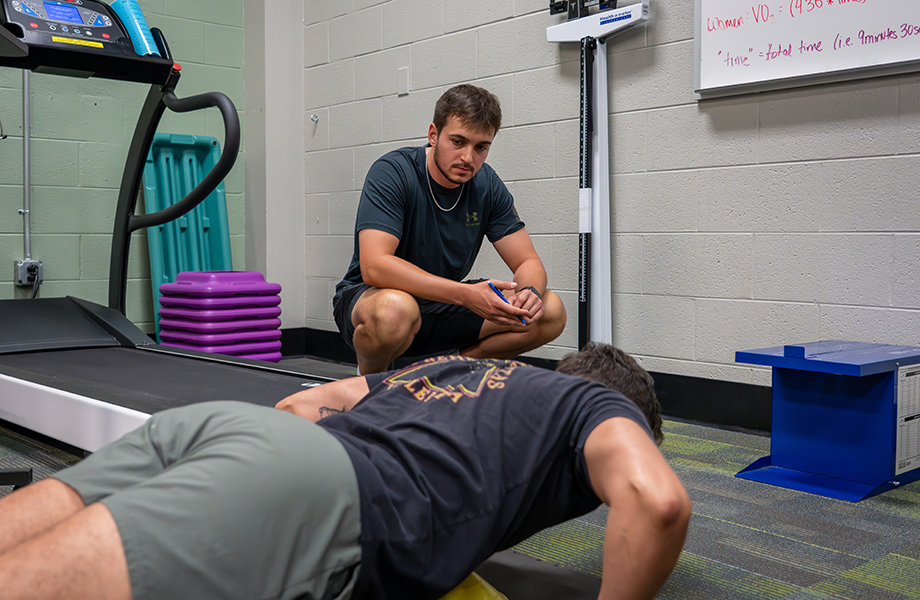 ESK staff member assists client doing pushups