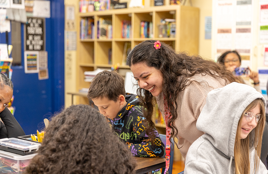woman works with students in a classroom