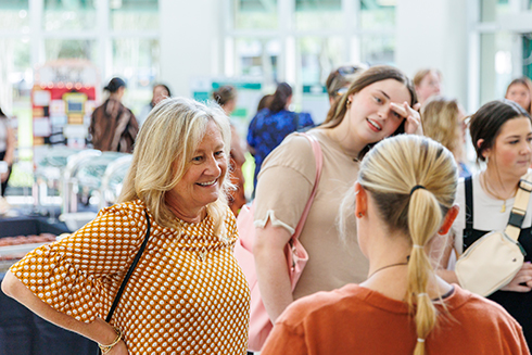 Students and participants speaking around poster presentations 