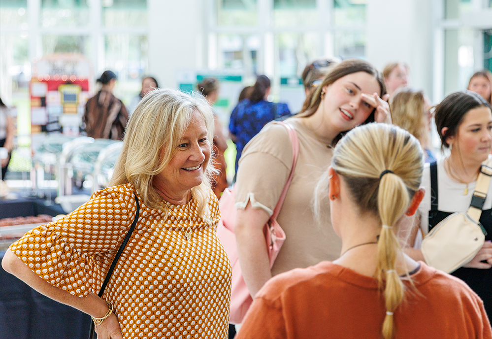 Students and participants speaking around poster presentations 