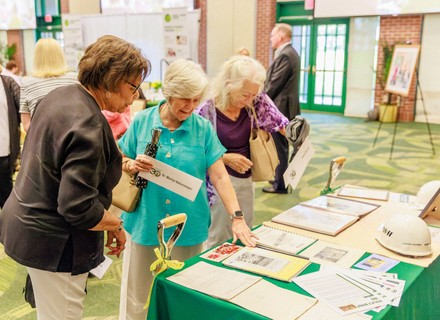 Marilyn Katzenmeyer looking through memories of the Anchin Center groundbreaking on its 30th anniversary.