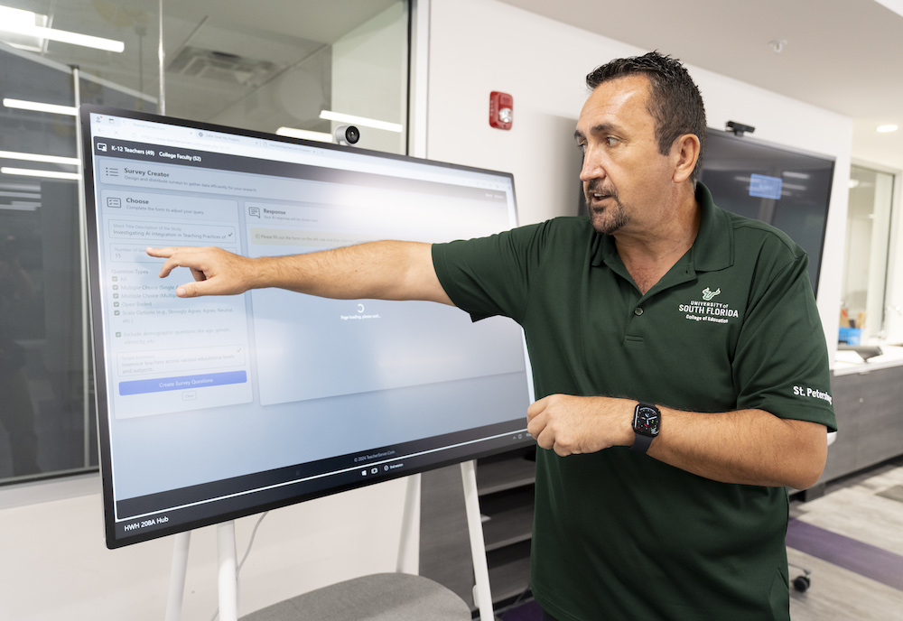 Zafer pointing at a screen to explain the site