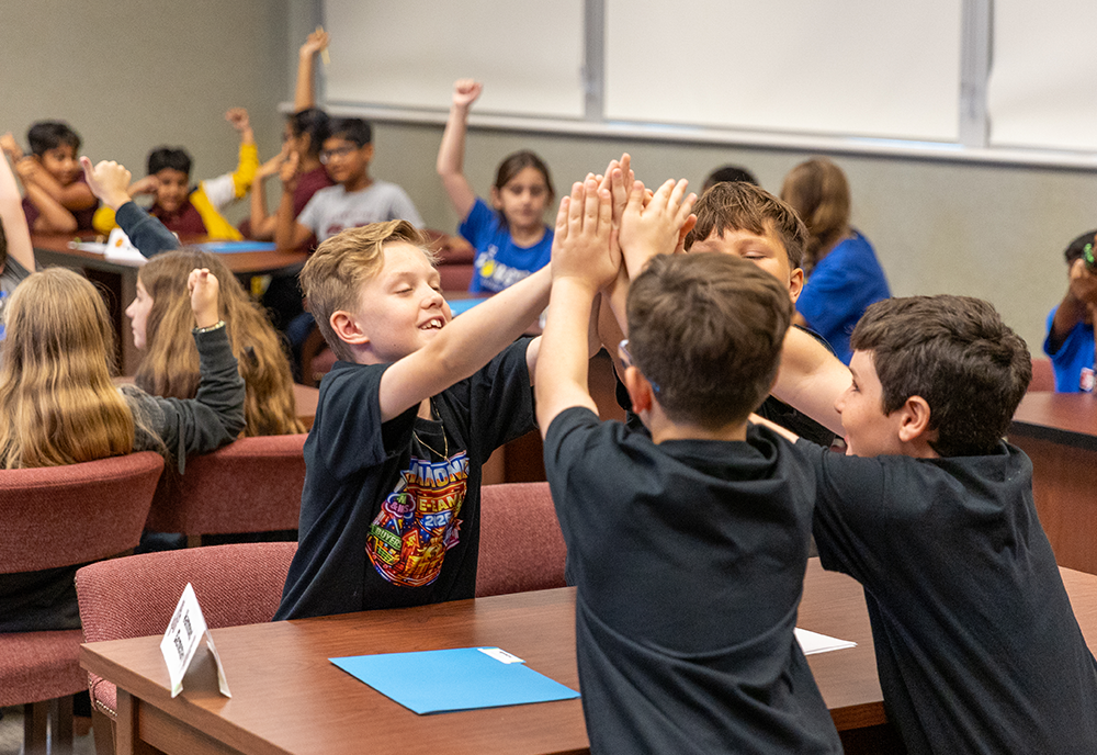 Kids high fiving each other