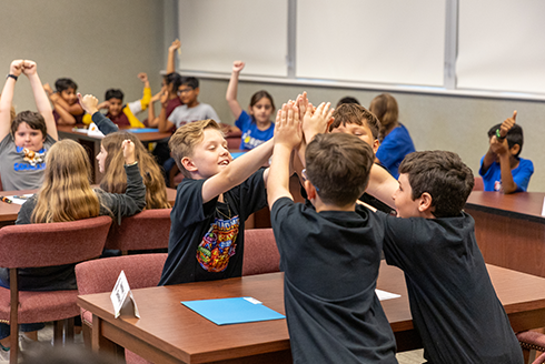Kids high fiving each other 