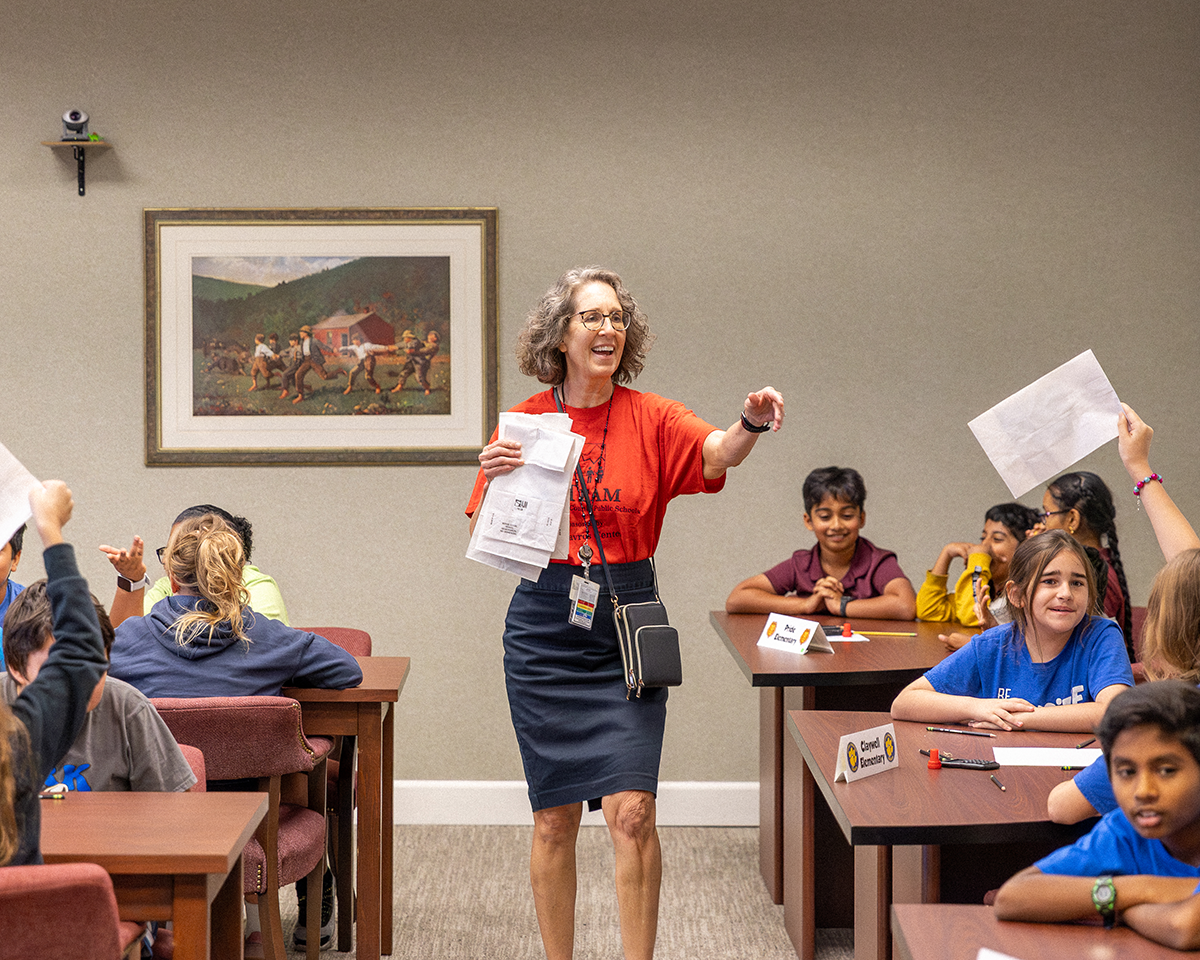 Teacher walking down smiling between tables
