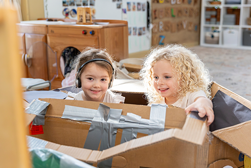 2 young children playing in preschool