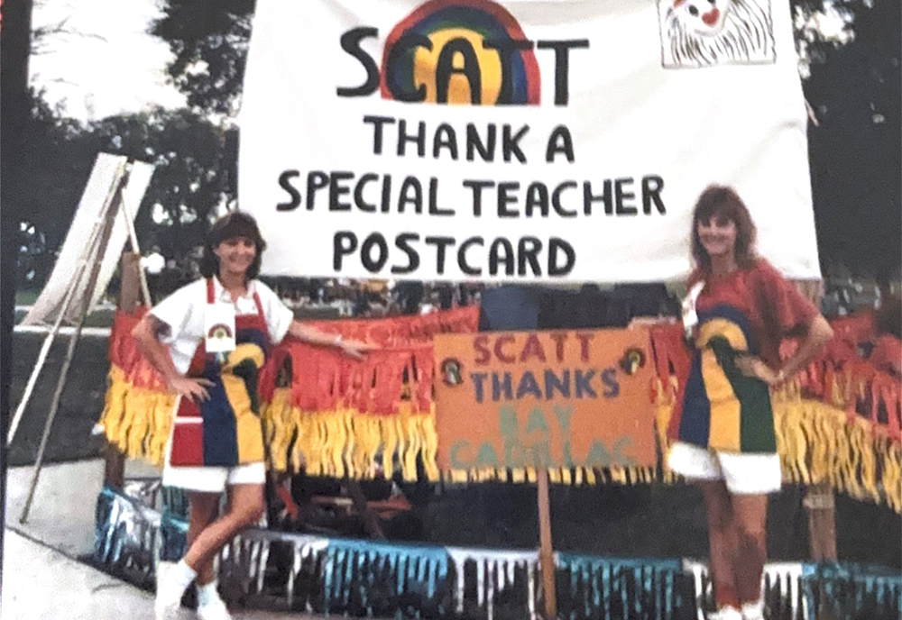 two SCATT students with sign saying "SCATT Thank a Special Teacher Postcard"
