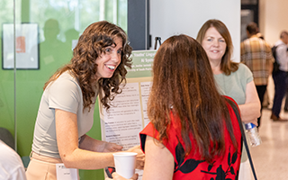 Leah Burger and Jenifer Jasinski Schneider with their poster and attendees