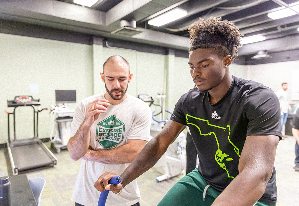 ESK student with Track & Field athlete on stationary bike