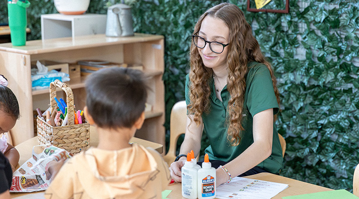 a women sits at a table with children smiling