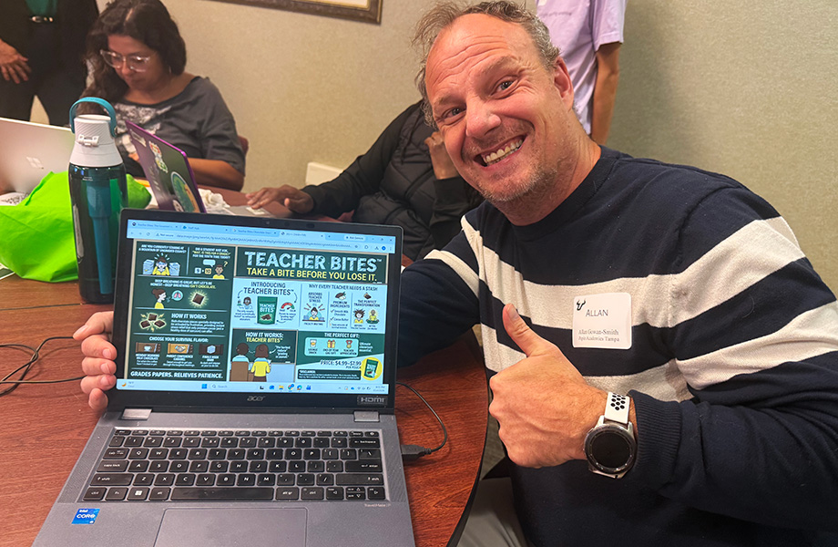 a man holds laptop and gives thumbs up to camera smiling with workshop activity on screen