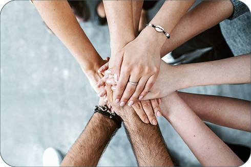 a bunch of hands stacked on top of each other