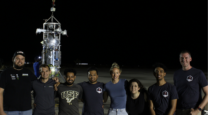 Team posing in front of launch