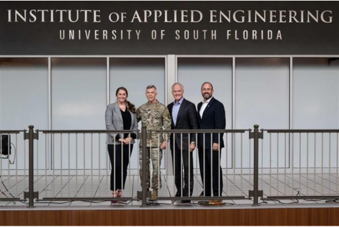Group of individuals standing in front of the Institute of Applied Engineering HQ