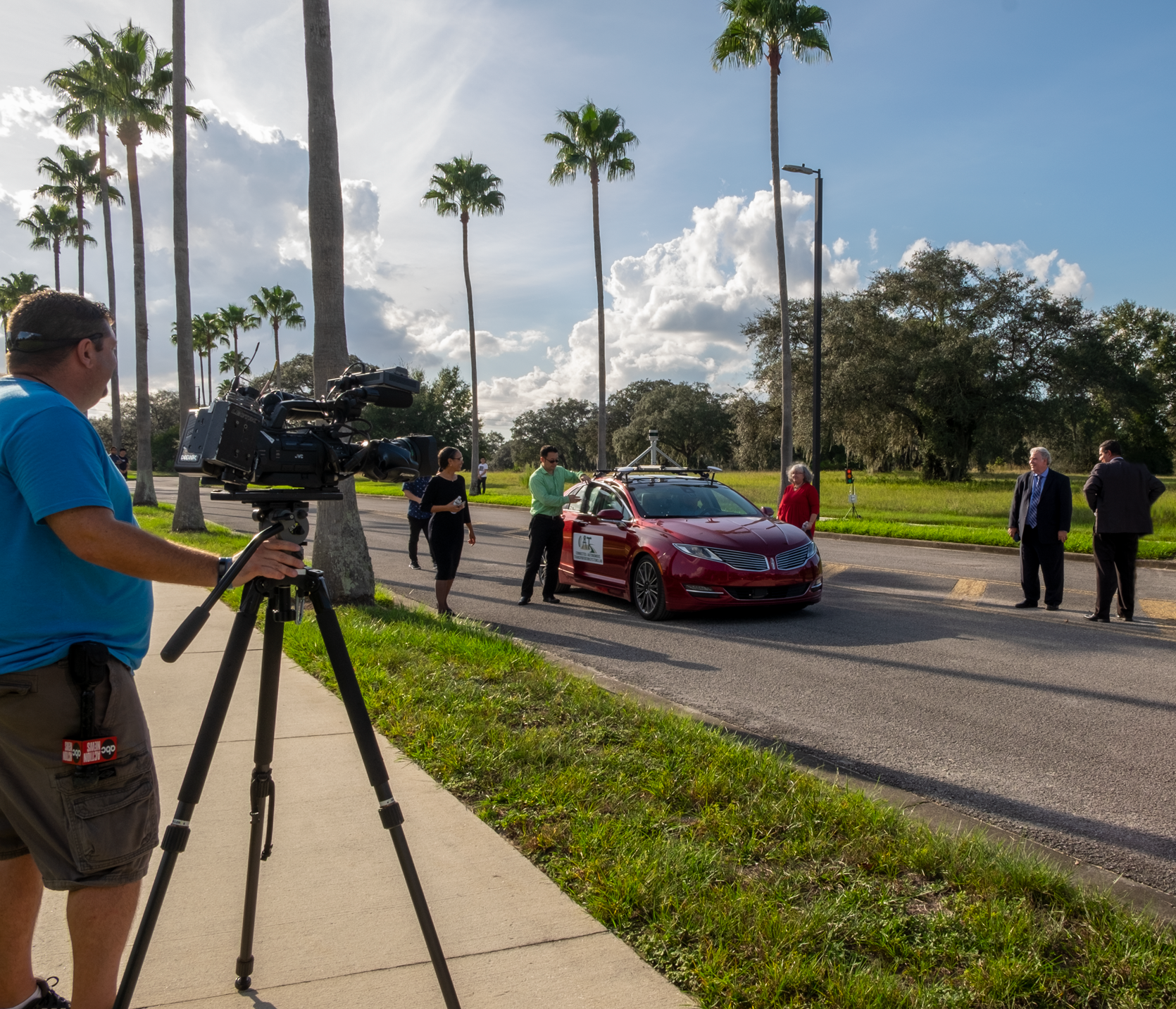 USF Civil and Environmental Engineering professor Xiaopeng (Shaw) Li (fourth from right), Ph.D., details features of his lab’s autonomous and connected vehicle to U.S. Department of Transportation representatives and guests during a technology demonstration at USF.