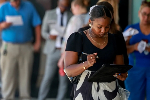 People wait for a job fair to open at the Amerant Bank Arena