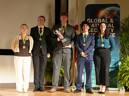 The students from UCF standing on stage with their championship trophy following the 2026 USF Undergraduate Strategy Competition