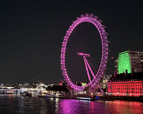 Nighttime view from across the River Thames of the London Eye Ferris Wheel
