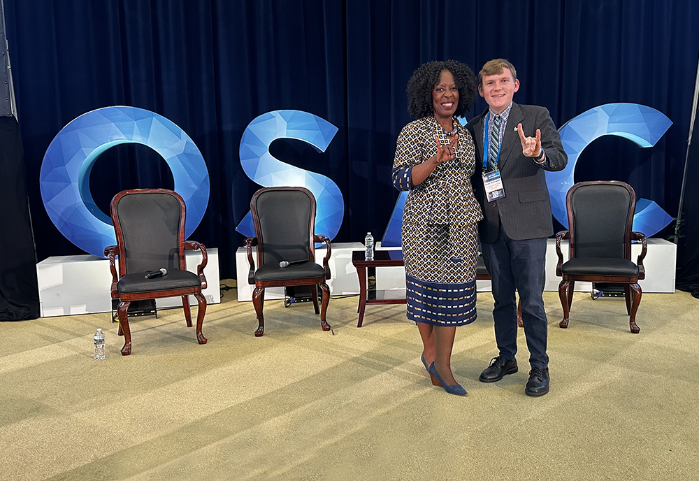 USF grad student, Sean Schrader, flashes the USF Bulls sign with OSAC Executive Director, Ellen Tanor