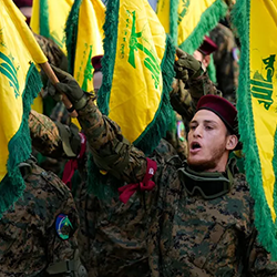 Hezbollah soldiers holding flags at a military parade in Lebanon