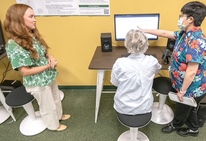 Marlena Bolton, left, and Ly Dinh, an assistant professor in USF’s College of Arts and Sciences, far right, speak to Jeanie Plyler, center, who is a volunteer to help train the SeniorSafeAI chatbot they are working to develop.