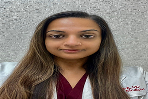 Dr. Mala Trivedi in a medical white coat and burgundy top
