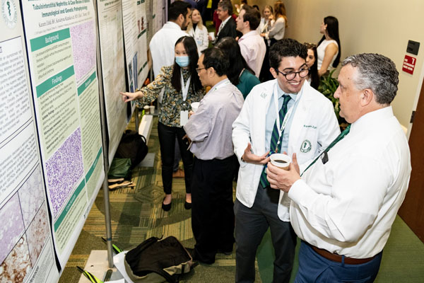 Third-year medical student Kareen Zuhdi presents his research findings to MCOM Vice Dean Dr. Bryan Bognar.